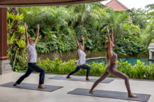 two women and a man doing a yoga session at Sakti Garden Resort and Spa